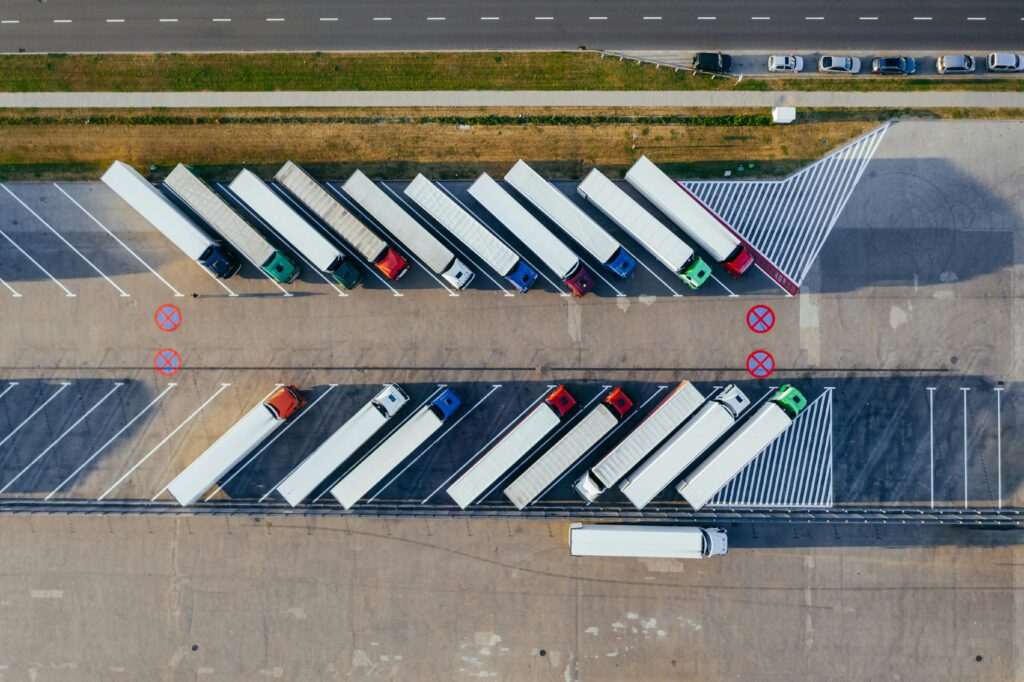 Overhead shot of semi-trucks parked in Poznań, Poland, demonstrating transportation logistics.